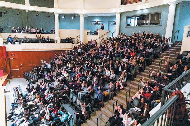  CUWiP participants greet each other during a video conference call with keynote speaker Dr. Fabiola Gianotti at the Mayo Concert Hall at The College of New Jersey. Photo courtesy of Andrew Cislak.