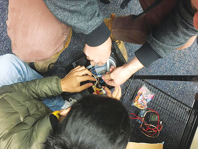 Students deconstruct a coffee machine. Photo by Iza Lazaneo.