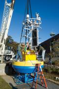 WHOI workers assemble a surface buoy for use in the Ocean Observatories Initiative, an effort to collect 25–30 years of ocean data for monitoring and analysis. Photo courtesy of the Woods Hole Oceanographic Institution.