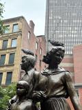 Statues wearing pigeon hats.